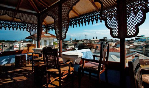 Några matbord i orientalisk stil på Emerson on Hurumzis takrestaurang, med utsikt över Stone Town.
