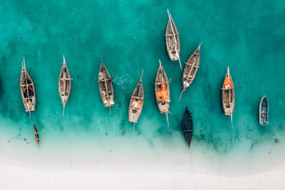 Top view or aerial view of Beautiful crystal clear water and white beach with long tail boats in summer of Zanzibar island